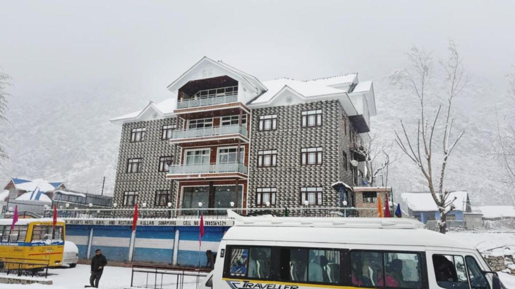 a bus parked in front of a building in the snow at Himalayan Stay in Sonāmarg