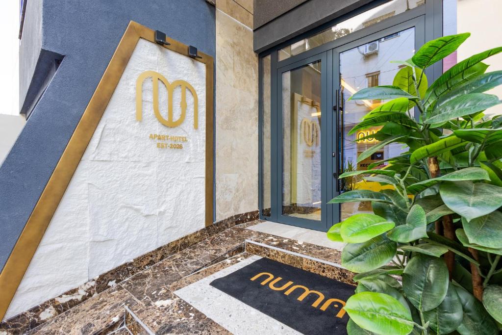 a door to a restaurant with a sign on it at Numa Apart-Hotel in Tirana