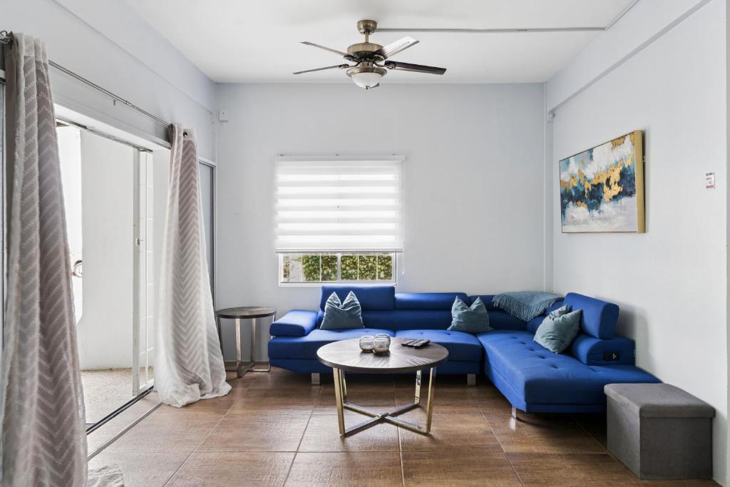 a living room with a blue couch and a table at Arcadian Place in Port-of-Spain