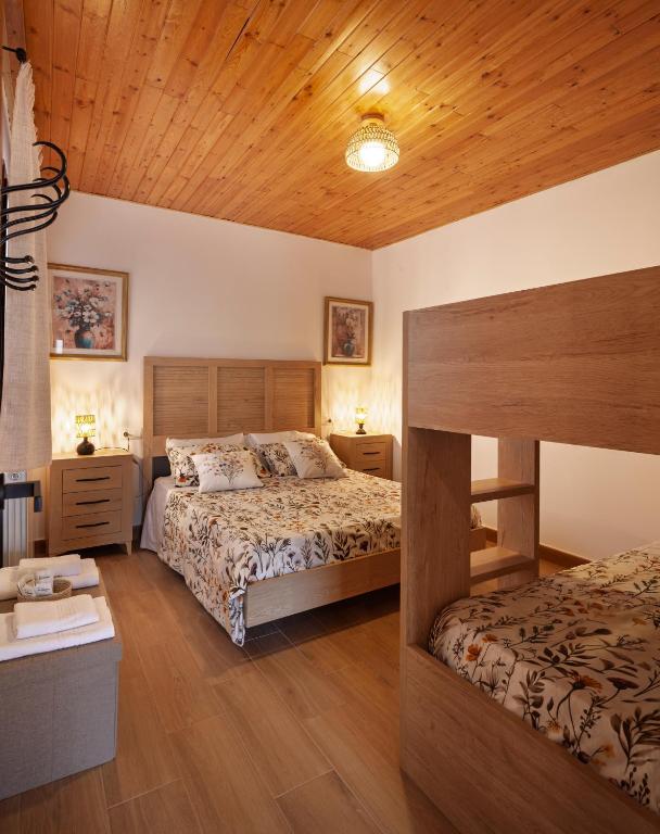 a bedroom with two beds and a wooden ceiling at Ca la Inés in Corbera