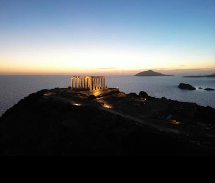 an island in the middle of the ocean at sunset at Casa MUSA in Keratea