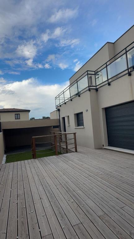 a large wooden deck in front of a house at Maison 3 chambres in Avignon