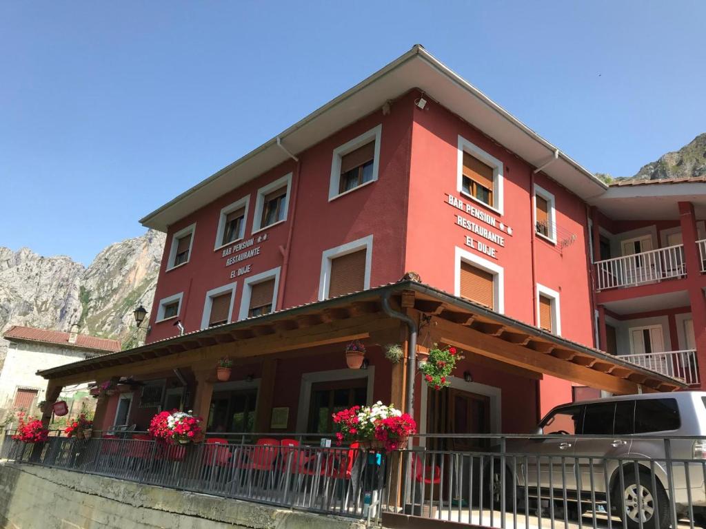 a red building with flowers in front of it at El Duje in Tielve
