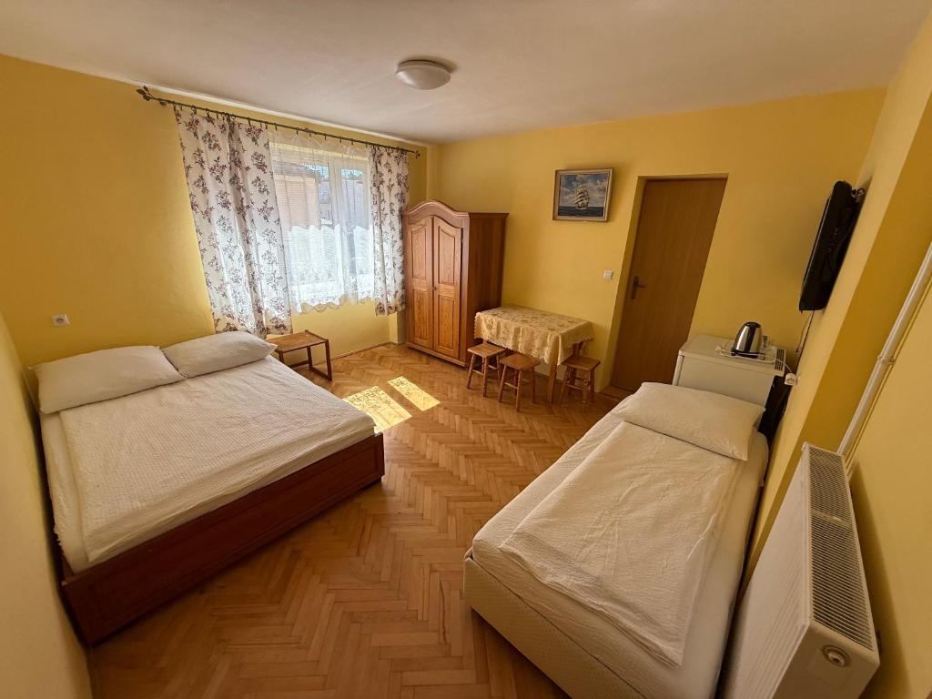 a small bedroom with two beds and a television at Villa Alexandria in Darłówko