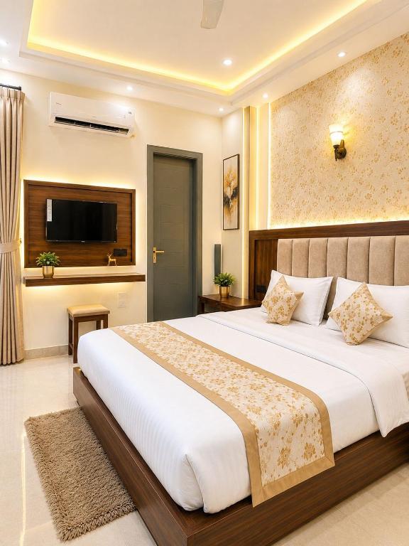 a bedroom with a large bed and a flat screen tv at Hotel Crystal Blues in Mathura