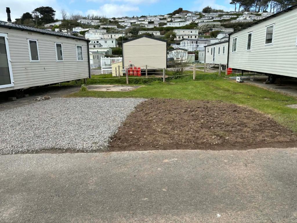 a pile of dirt next to a row of mobile homes at Challaborough caravan in Burgh Island