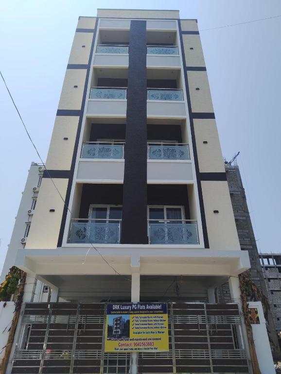 a tall white building with a sign in front of it at DRK Luxury Stays in Siruseri