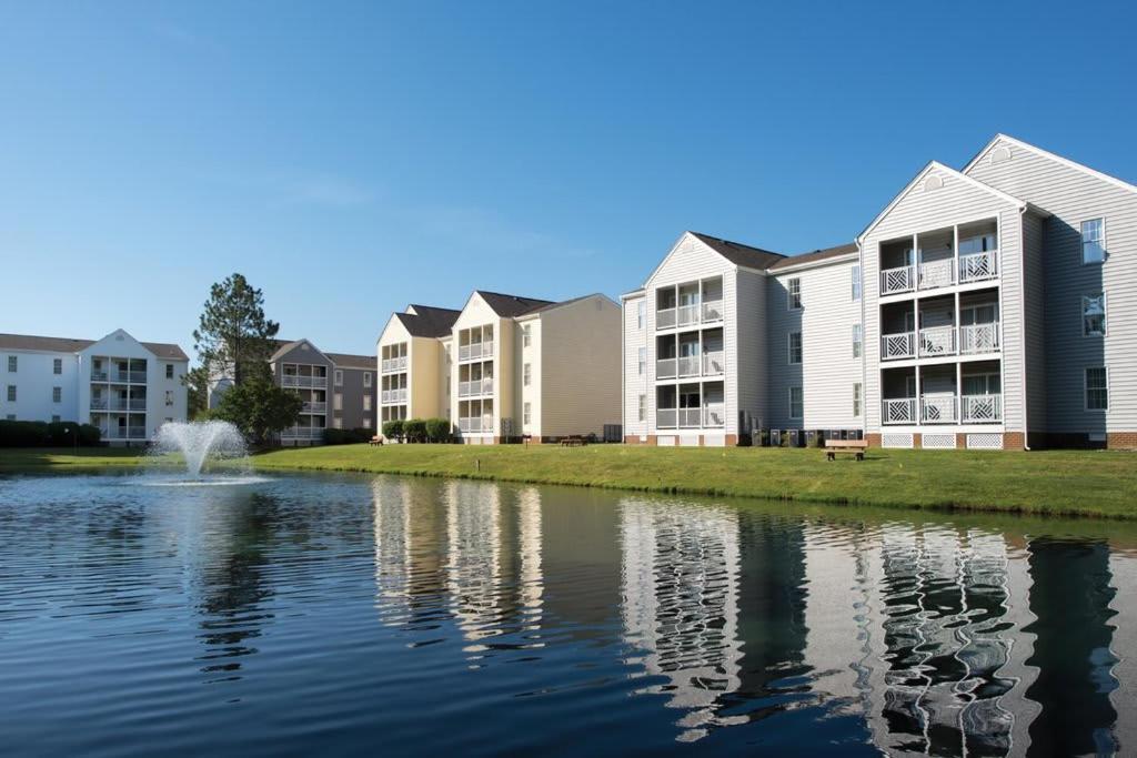 a row of apartment buildings next to a body of water at Kingsgate Resort 2BR Apartment in Williamsburg