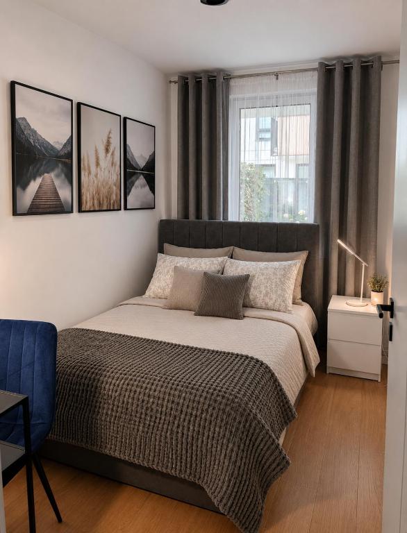 a bedroom with a large bed and a window at Apartament Pod Modrzewiem in Augustów
