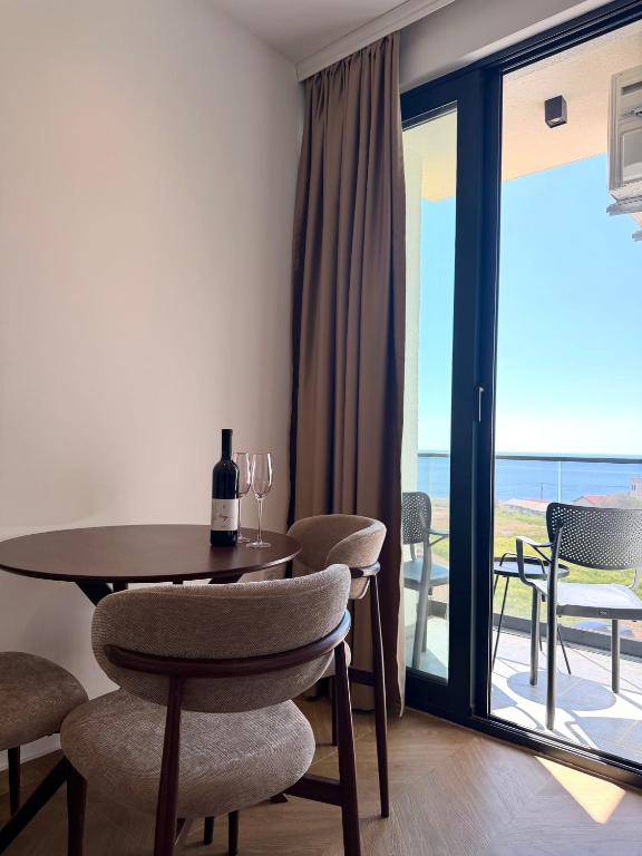 a dining room with a table and chairs and a balcony at Maresa 4 in Čanj