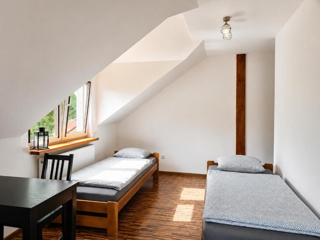 a room with two beds and a table and a window at Agroturystyka Pod Dębem in Czyżówek