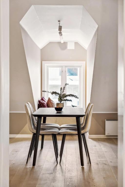 a dining room with a table and chairs and a window at 70 Degrees North City Apartments in Tromsø