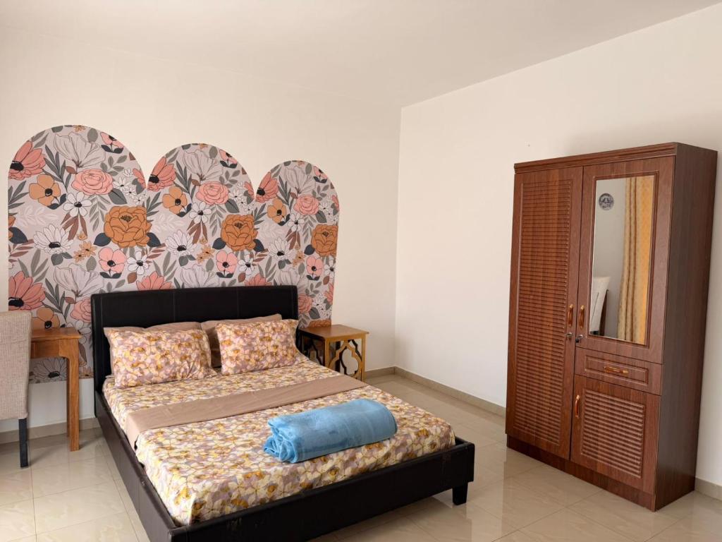 a bedroom with a bed with a blue pillow on it at Anta's House Sipres - Chambre calme et confortable in Dakar