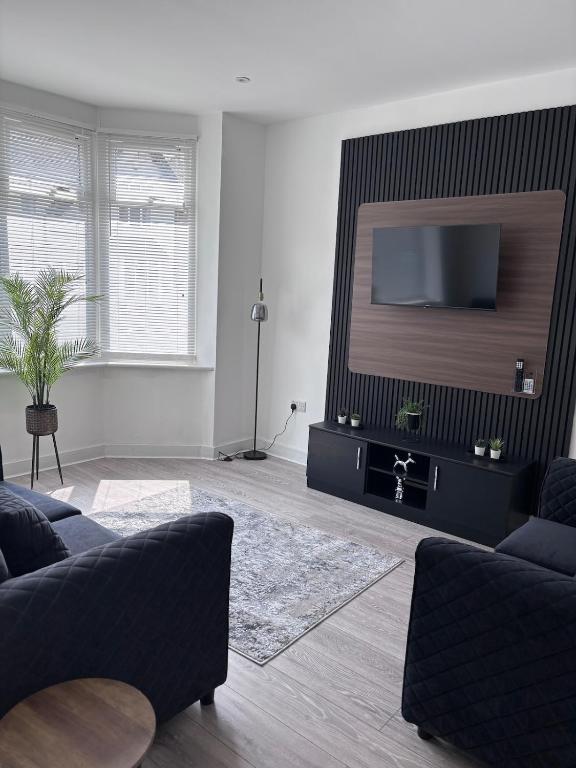 a living room with a flat screen tv on a wall at The Lenton House in Nottingham