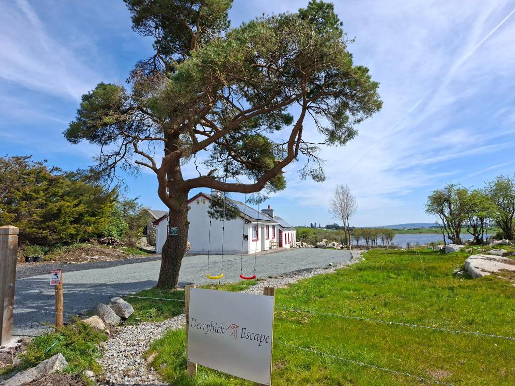 a sign in front of a house with a tree at Derryhick Escape in Crillaun