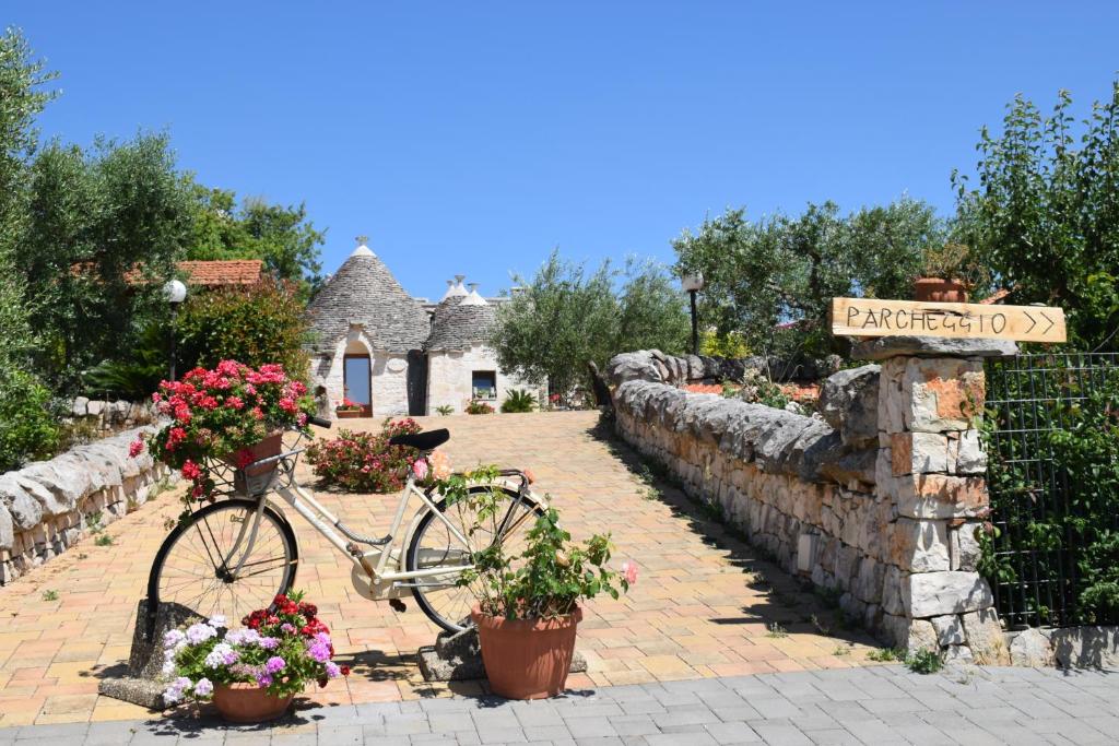 a bike parked in front of a house with flowers at B&B La Rosa dei Trulli Alberobello in Alberobello