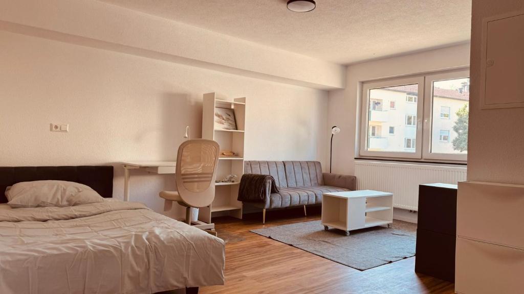 a bedroom with a bed and a desk and a chair at Cozy & small apartment-Böblingen in Böblingen