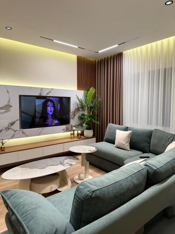a living room with a couch and a tv at Modern Luxury Apartment-City Center-Walk Anywhere in Durrës