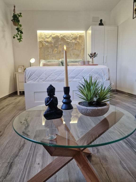 a living room with a glass table with a candle on it at La Petite Finca in Elche