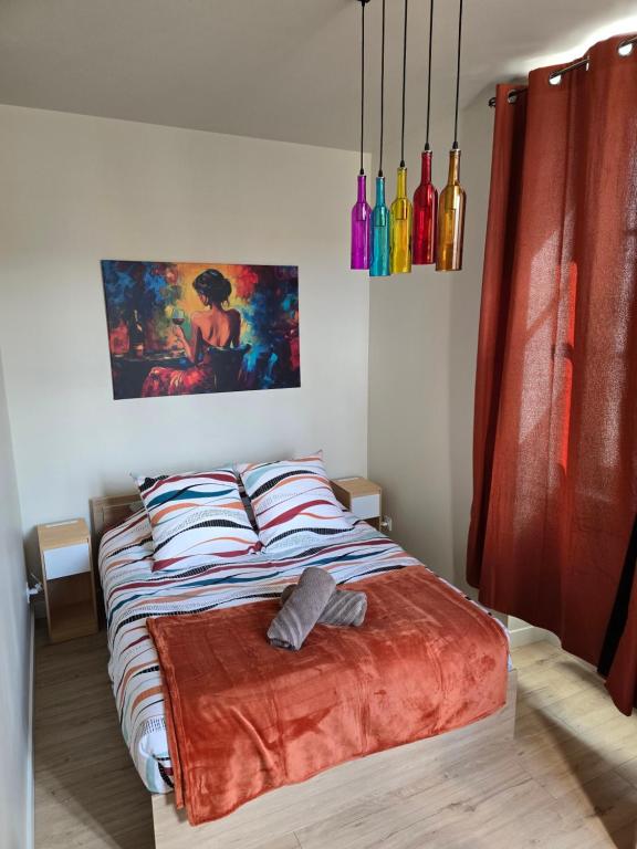 a bedroom with a bed with a painting on the wall at L'Escapade Chablisienne in Chablis