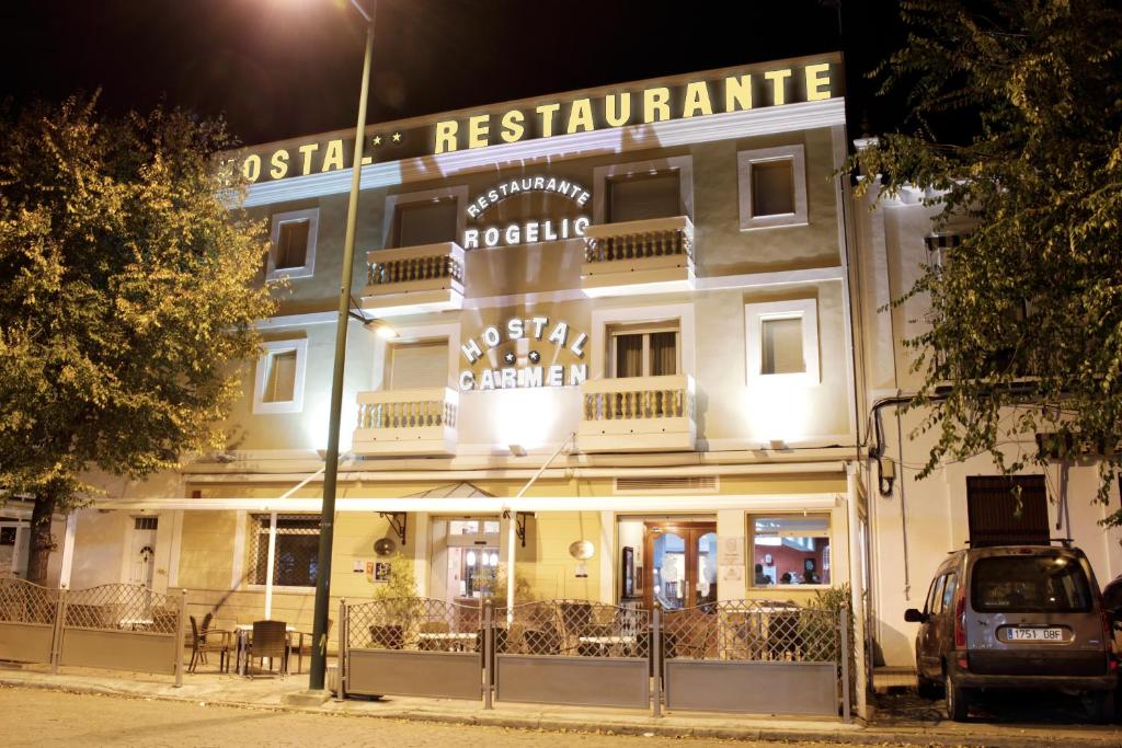 een gebouw met een bord voor een restaurant 's nachts bij Hostal Carmen in Zafra