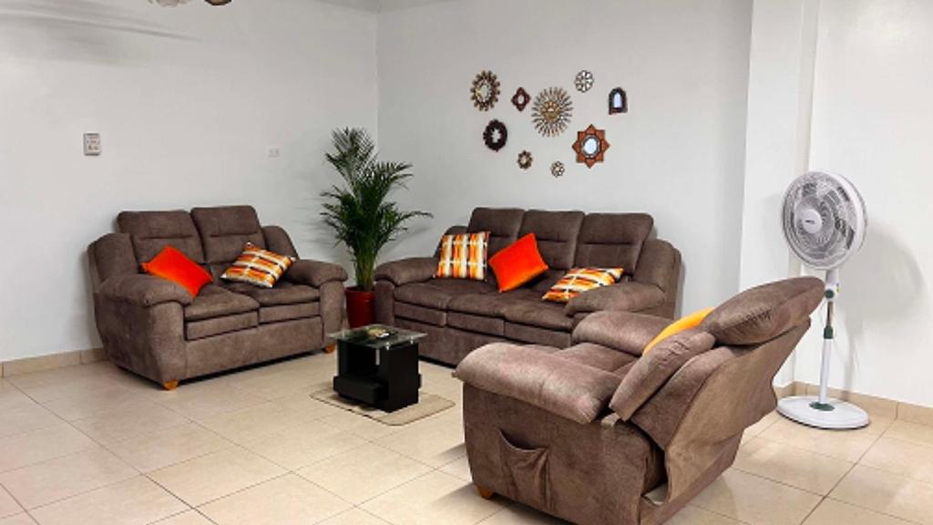 a living room with two couches and a fan at La Casa Rustica in Puerto Chicama