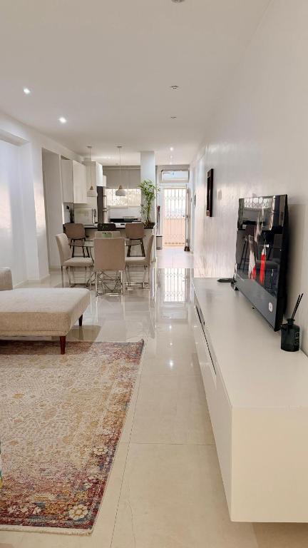 a white living room with a couch and a table at 3 Ls APARTAMENTO in Luanda