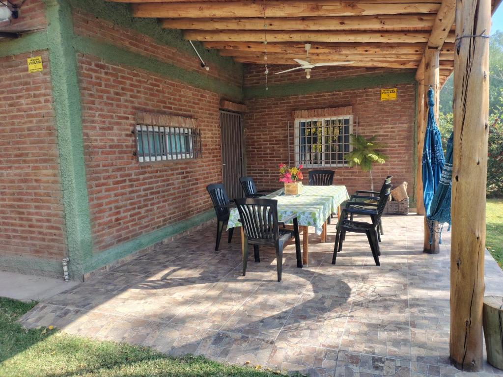 a patio with a table and chairs and a brick wall at Cabaña María Lourdes in Maipú