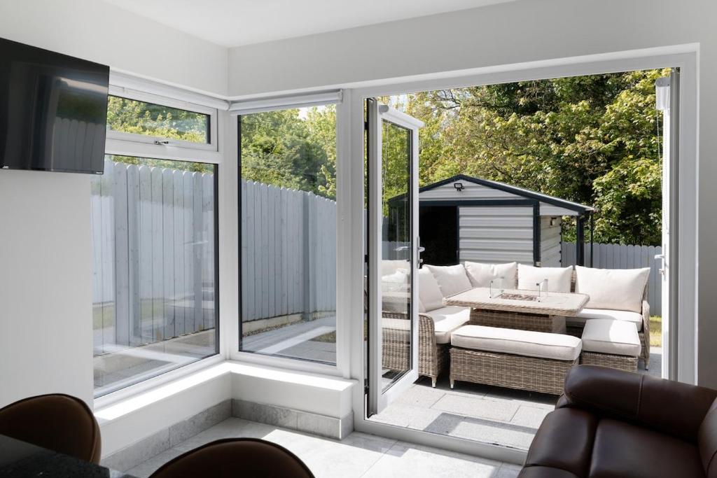 a screened in porch with a couch and a table at Castlecroft House with Hot Tub in Dungiven