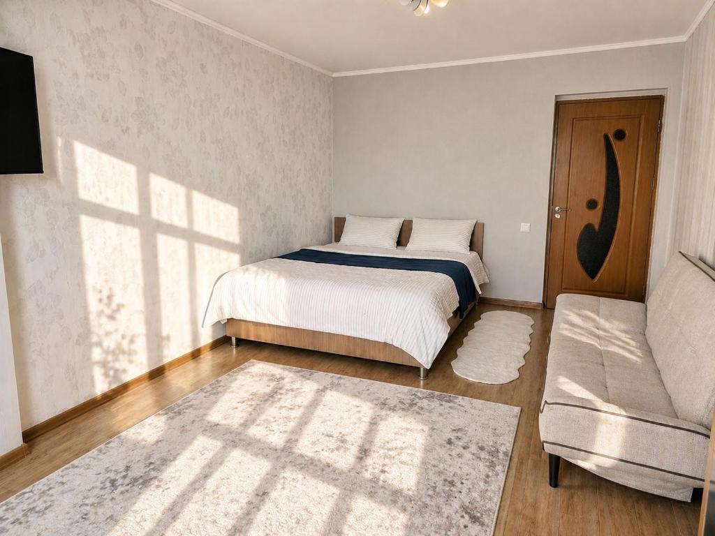 a bedroom with a bed and a couch at Apartament in Botanica in Chişinău