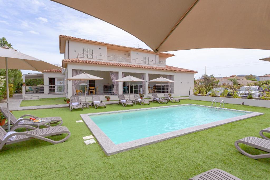 a villa with a swimming pool in front of a house at Le dune relax con cucina & piscina in San Teodoro