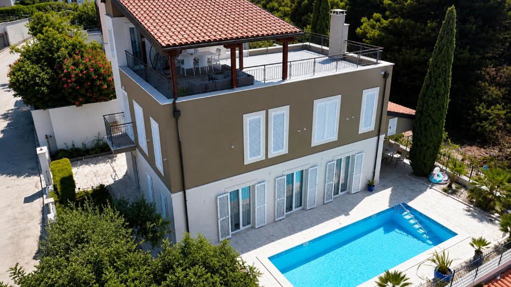 an aerial view of a house with a swimming pool at Villa Igalo Splitska - Private Pool & Sea View in Splitska