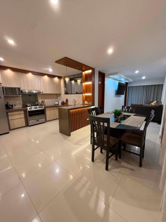 a large kitchen with a table and chairs in it at Departmento Grande in Puerto Chicama