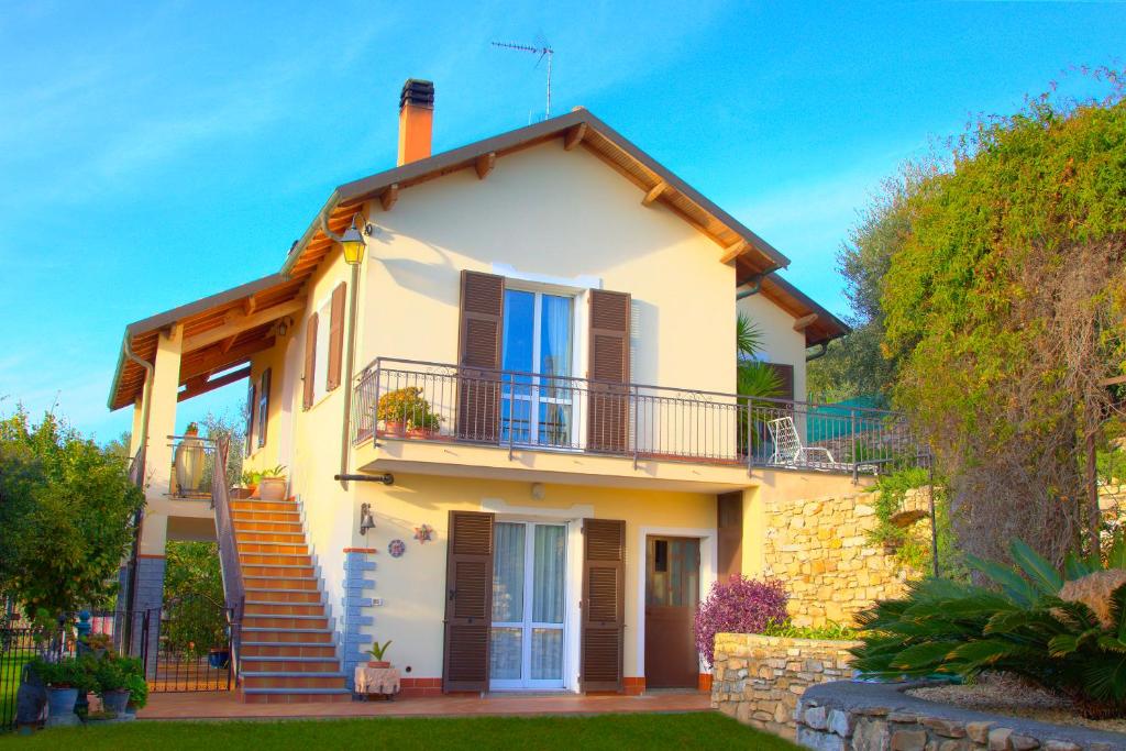 una casa gialla con balcone e scale di Guest House Luciana a Diano Castello