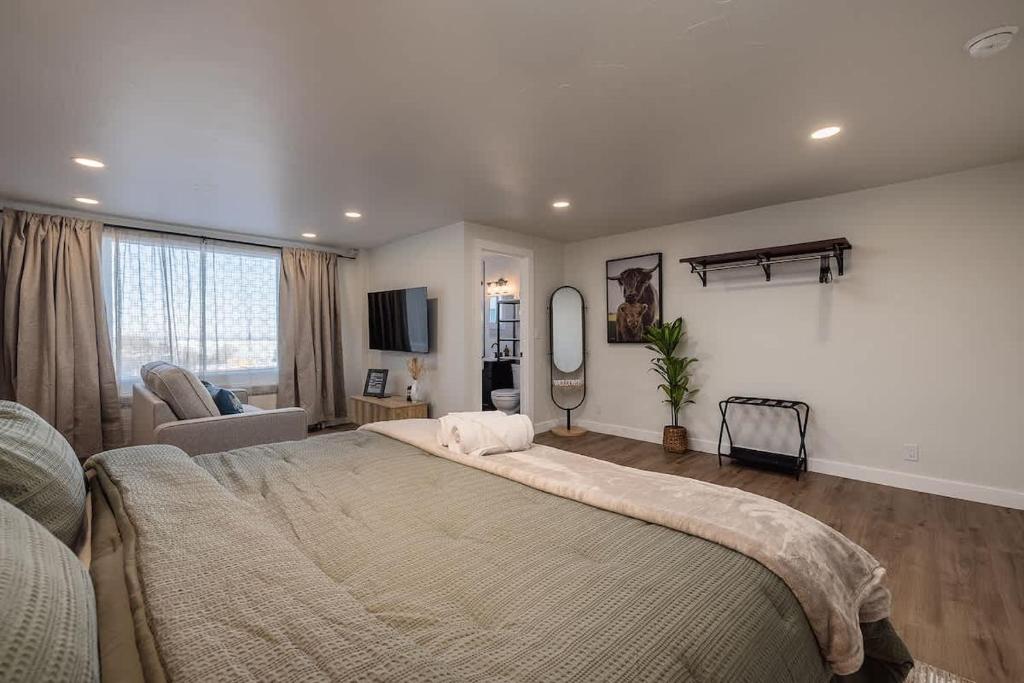a bedroom with a large bed and a living room at Modern Downtown Studio - King Bed - Inlet Views in Anchorage