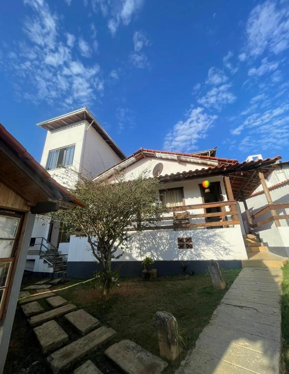 a white house with a blue sky in the background at Casa vicentina in Tiradentes