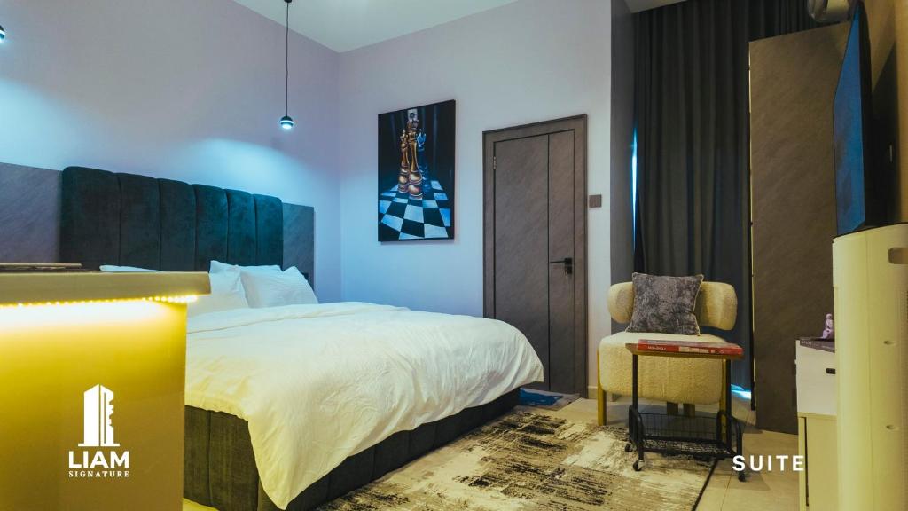 a hotel room with a bed and a chair at Studio Apartment -LIAM Signature Akowonjo Egbeda in Akinde