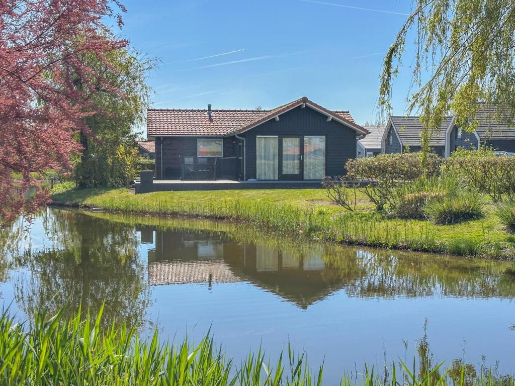 a house next to a river with a house at Zout en Peper in Kattendijke