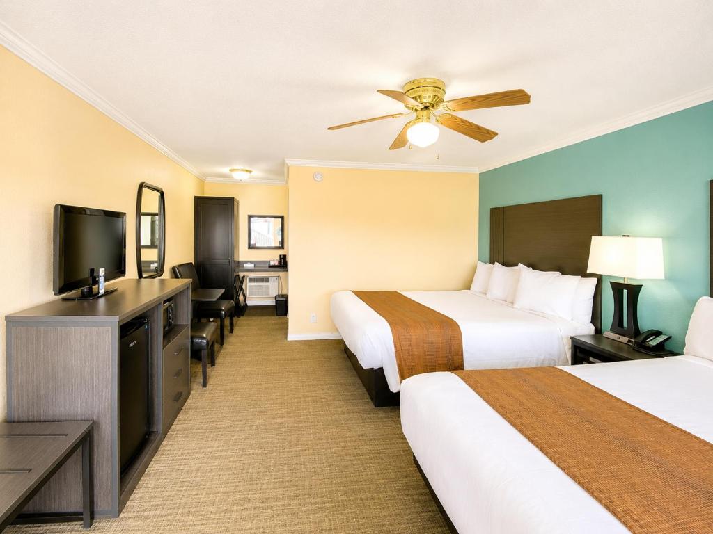 a hotel room with two beds and a flat screen tv at Rockview Inn and Suites - Morro Bay CA in Morro Bay
