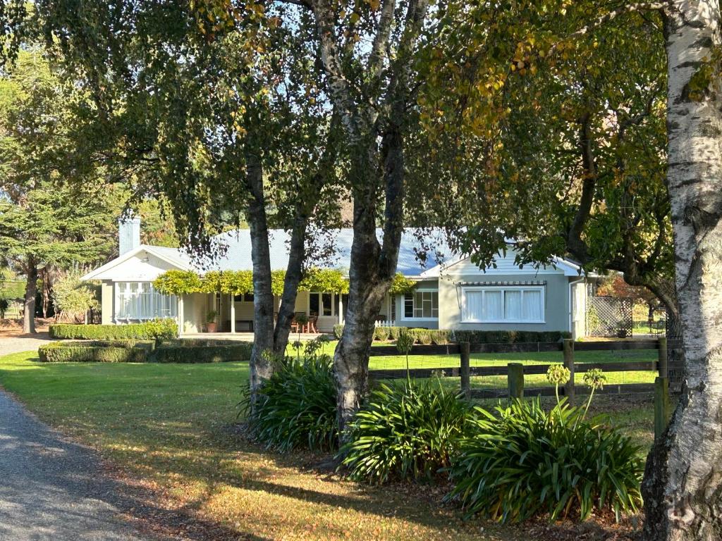 a white house with trees in front of it at Amberley Lodge in Amberley