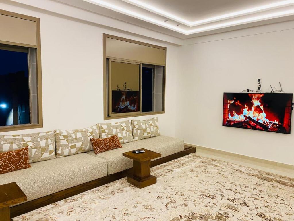 a living room with a couch and two windows at Appartement Kais in Laayoune