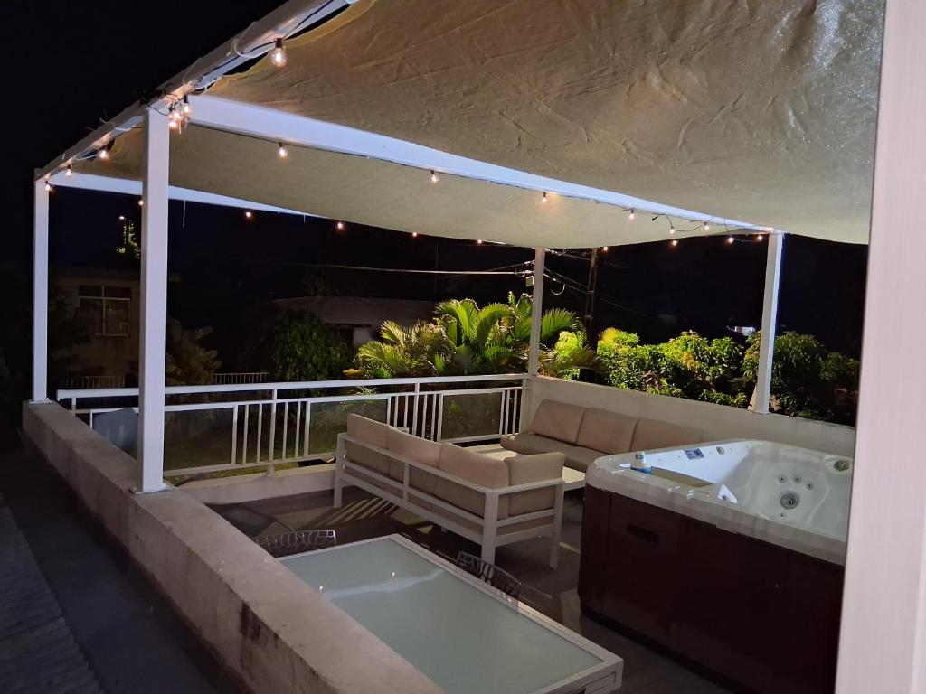 a jacuzzi tub on a balcony at night at La terrasse in Baie-Mahault
