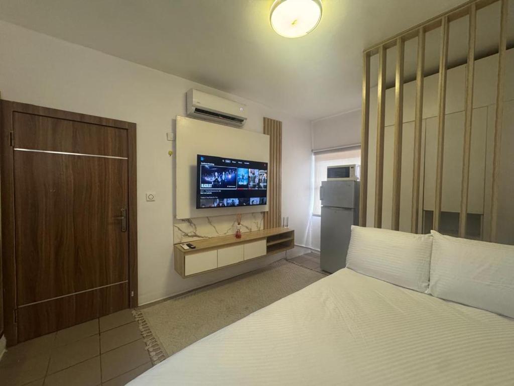 a bedroom with a bed and a television on the wall at Exquisite 1-bed studio apartment in Ikoyi in Lagos