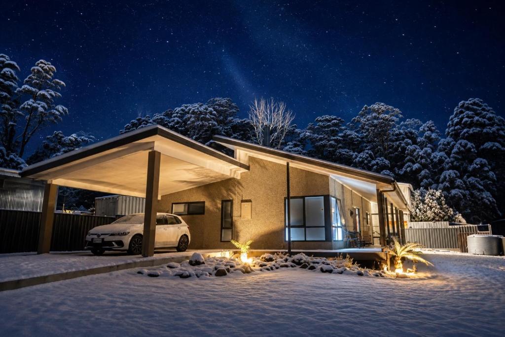 ein Haus mit einem Auto, das nachts im Schnee geparkt ist in der Unterkunft Bronte Snug in Bronte