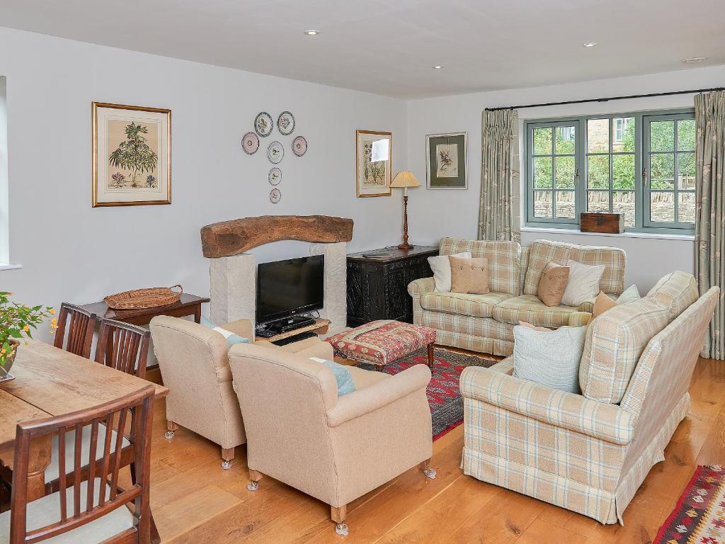 a living room with two couches and a television at Kites Gate Cottage in Kingham