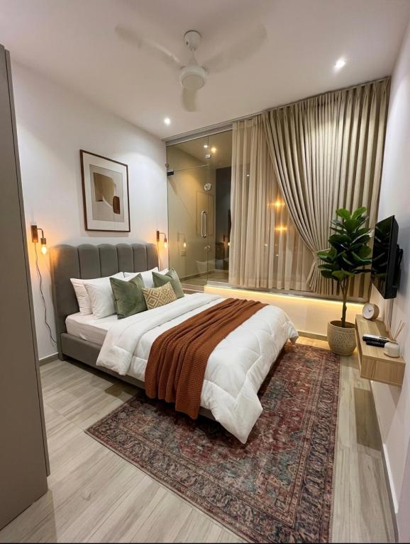 a bedroom with a large bed and a large window at SM residence in Lahore