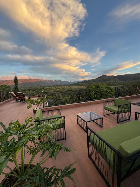 a deck with tables and benches and a view at Pousada Belvedere da Serra in Serra do Cipo