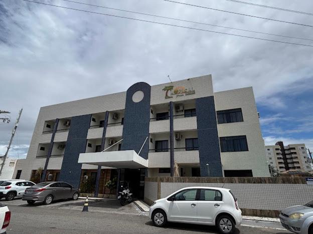 a white car parked in front of a building at Tropical Praia Hotel in Aracaju