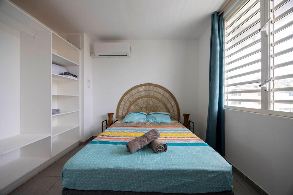 a bedroom with a bed with towels on it at Appartement bois de chaumes in Cayenne