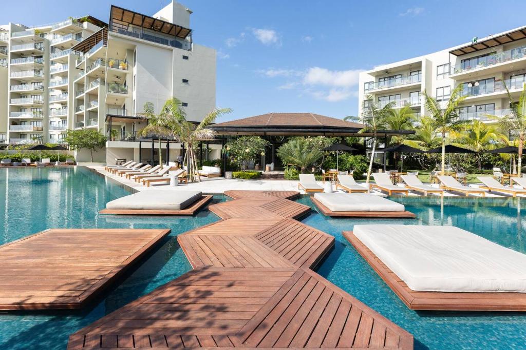 a swimming pool with lounge chairs and a hotel at The Friendly Condo by AcoModo Punta Caelo in El Nance